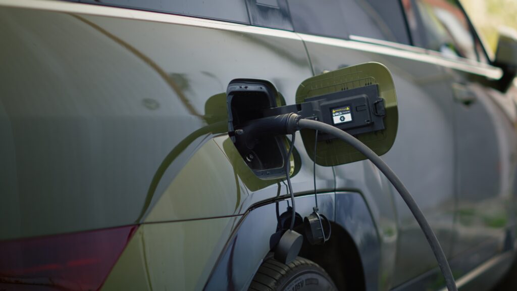 Close up shot of electric SUV automobile charging at modern station